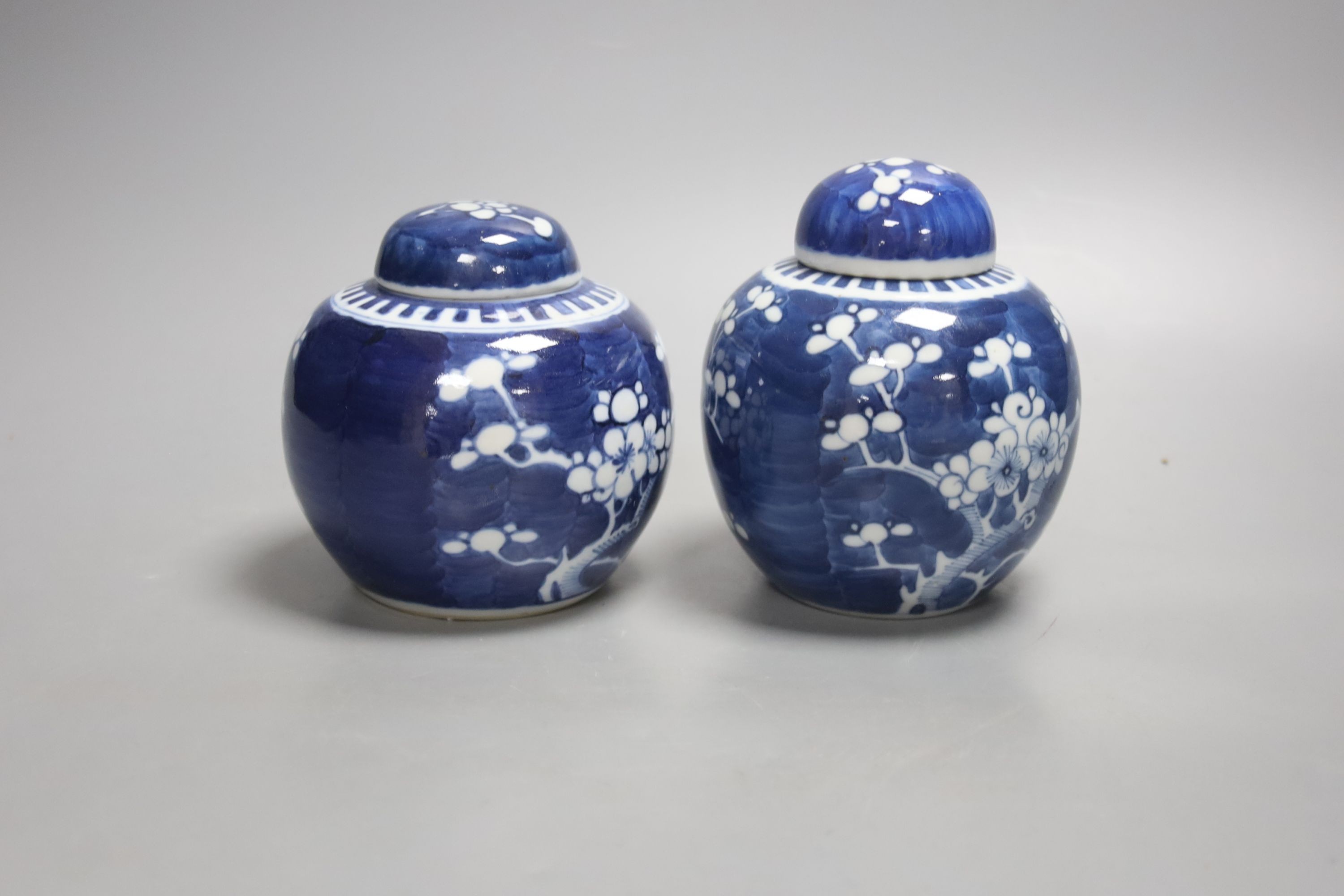 A pair of early 20th century blue and white prunus jars and covers